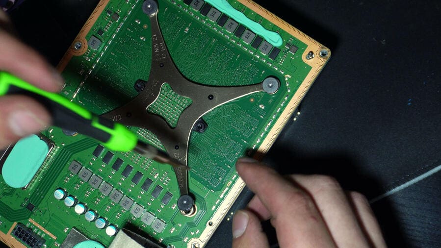 Xbox Series X mainboard with the APU retention bracket exposed and fresh thermal pads being fitted on the Circuit Rescue workbench.
